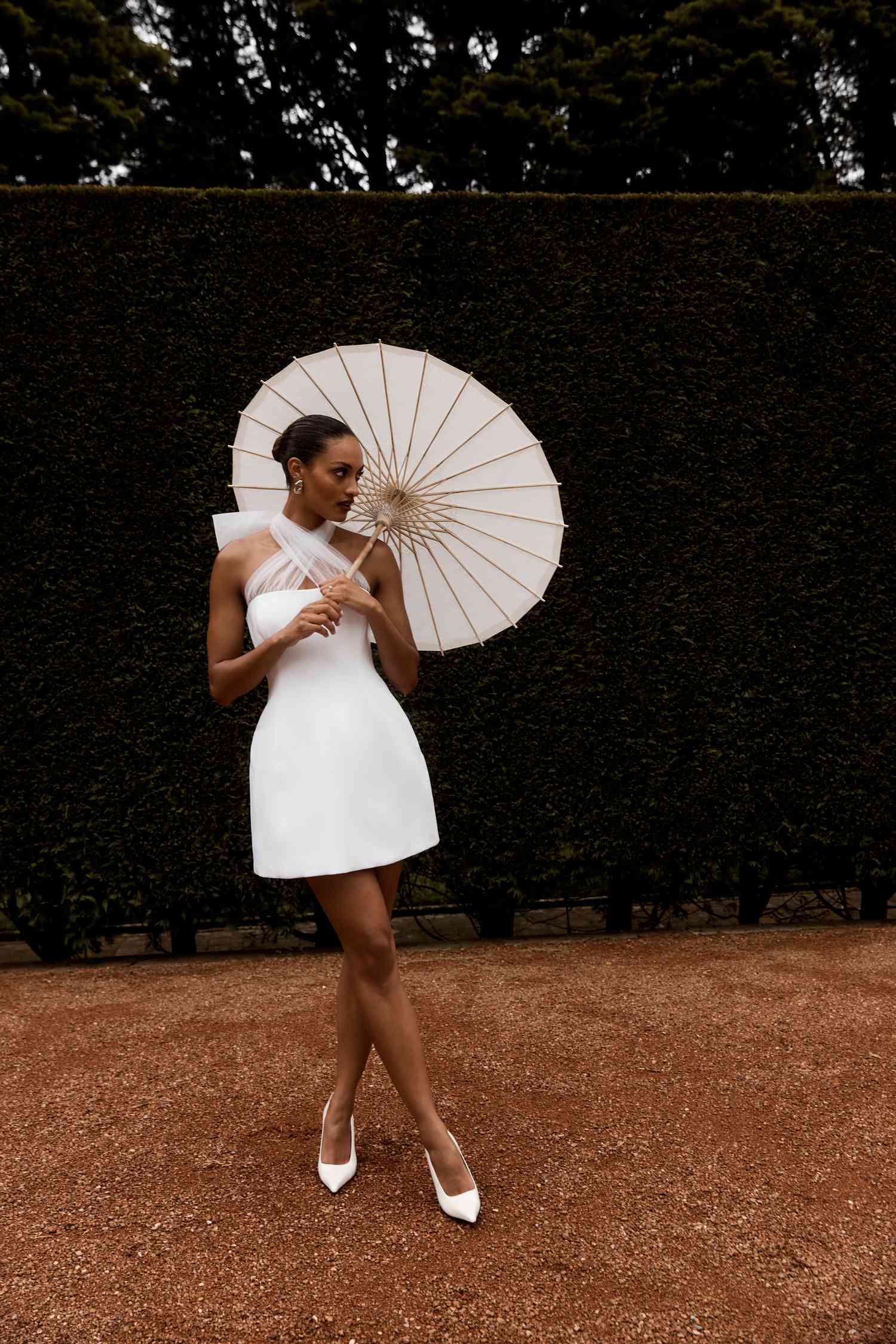 bride wearing a mini wedding dress holding a parasol